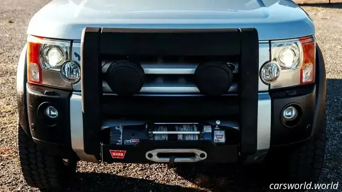 Этот незаметный внедорожник скрывает американский V8 мощностью 550 л.с. и рычит как масл‑кар, при этом сохраняя свой классический внедорожный характер
7 часов назад

автор: Брэд Андерсон

Legacy Overland заменил двигатель на форсированный 6,8‑литровый LS3 V8.

Улучшенный мотор развивает 550 л.с. и 550 фунт‑футов крутящего момента.

При этом сохранены оригинальная система полного привода и британская электроника.

Discovery третьего поколения, известный в США как LR3, никогда не был спортивным внедорожником. Предлагавшийся с V6 или V8, он имел максимум 300 л.с. — достаточно для поездки со школьниками, но мало по современным меркам. Этот LR3, недавно переработанный Legacy Overland, немного другой.

Под капотом этого Discovery больше нет двигателя сомнительной надёжности. На его месте установлен двигатель LS3 V8 производства GM, увеличенный до 6,8 литра и настроенный на выдачу 550 л.с. и таких же внушительных 550 фунт‑футов крутящего момента. Это почти вдвое больше, чем выдавал новый автомобиль с завода.

Читать: В этом винтажном Toyota с V8 нет ничего сдержанного

Возможно, ещё более впечатляет не сам факт установки V8 в моторный отсек, а то, что он и автоматическая коробка передач GM 6L80 были перепрограммированы для работы в синхроне с оригинальной электроникой Land Rover — или, по крайней мере, так утверждает Legacy Overland.

Конечно, хотите ли вы полагаться на британскую электронику начала 2000‑х — уже другой вопрос. Тем не менее все оригинальные системы в сети и функционируют, включая систему постоянного полного привода.

Что ещё было модернизировано?

Помимо нового двигателя и коробки передач, этот LR3 оснащён индивидуальными карданными валами, усиленными поперечинами, новой подвеской и улучшенной тормозной системой с новыми тормозными колодками.

В отличие от некоторых других недавних тюнингов Land Rover, которые мы видели, этот в основном сохраняет оригинальный внешний вид внедорожника и ничем не выдаёт по внешности, какой двигатель скрывается под капотом. Среди добавленных опций — лебёдка спереди, задняя лестница и багажник на крыше, а также полированные наконечники выхлопной системы.

В салоне ситуация схожа. Планировка кабин в основном оригинальна, но установлены новые приборы и обновлённый дисплей мультимедийной системы, интегрированный с ключевыми системами.

Все сиденья также перетянуты новой мягкой кожей, установлена улучшенная аудиосистема. Конечно, мы полагаем, что новый владелец предпочтет слушать V8, а не громко включать любимую музыку.